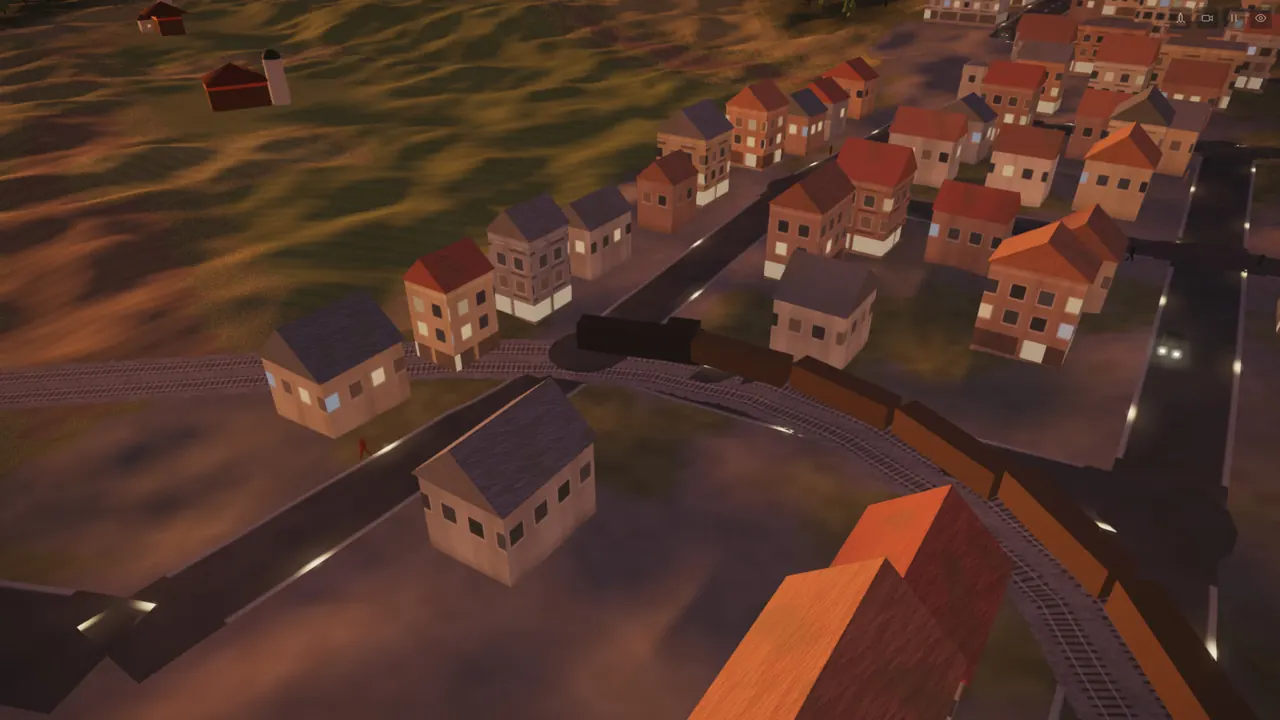 A freight train on the double track, through a town at dusk.